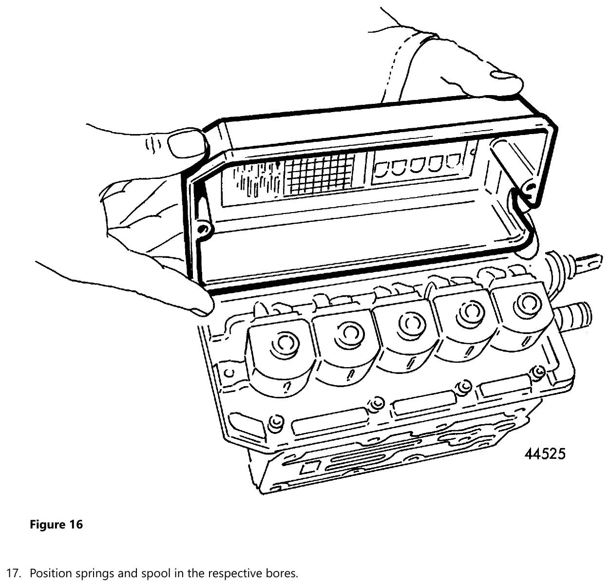 Válvula seletora de marchas da Volvo HT201 aberta na bancada, com os cinco alojamentos de solenoide, as corrediças e a tampa sendo posicionada pelo mecânico